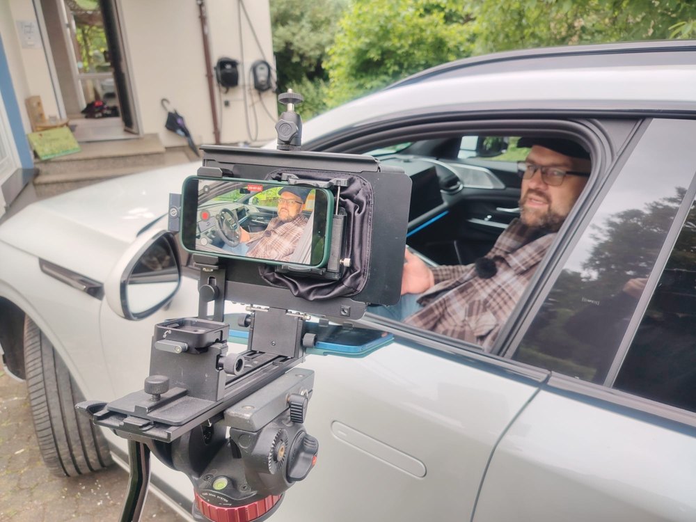 Kamera am Autofenster fuer eine Aufnahme im Fahrzeug