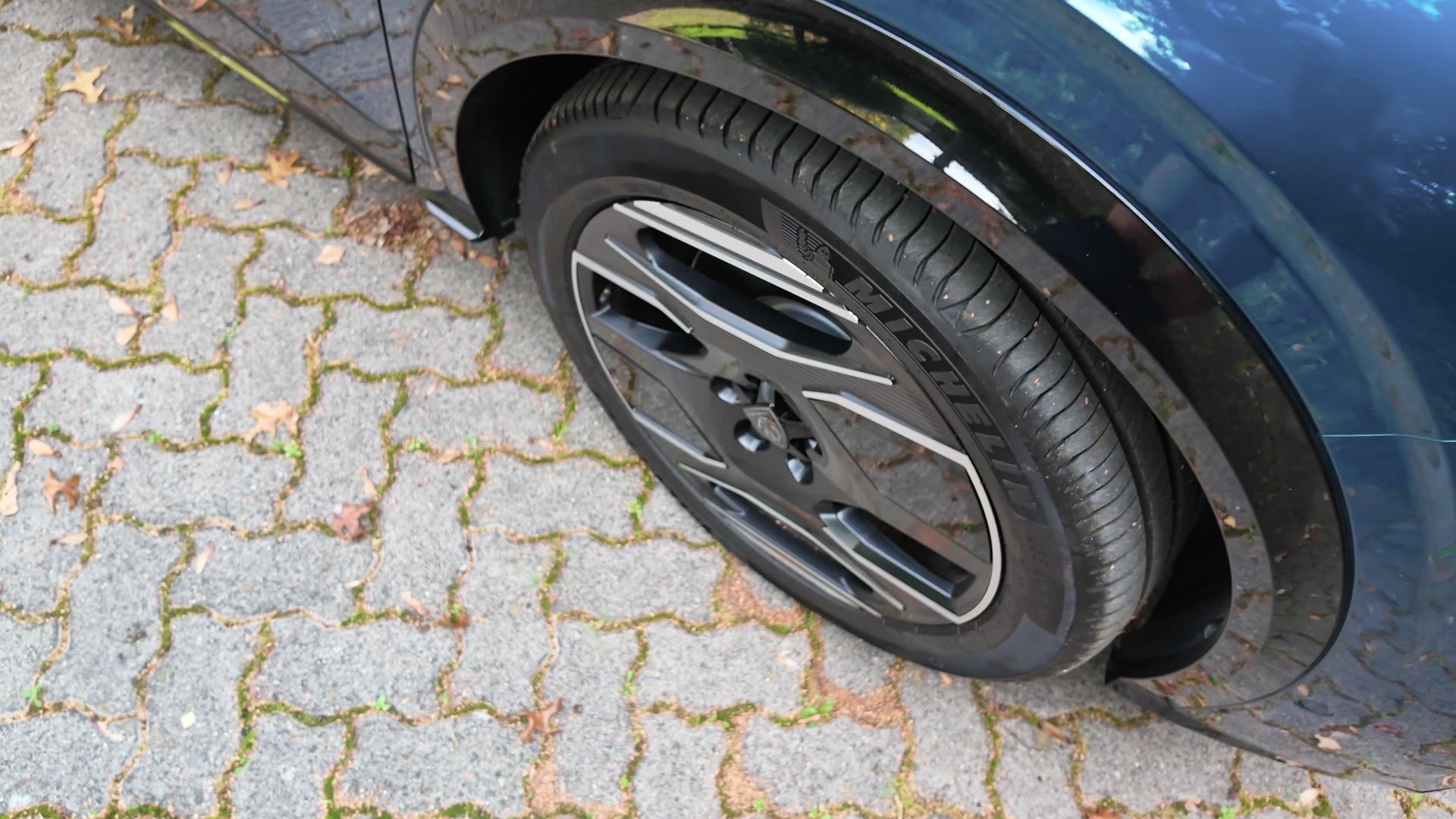 Nahaufnahme einer Leichtmetallfelge des Peugeot E-5008 mit Michelin-Reifen auf Pflasterboden