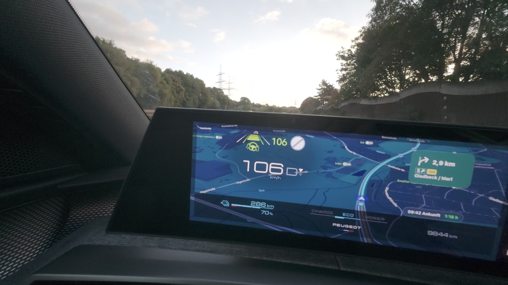 Panorama-Display des Peugeot E-5008 mit Navigationskarte, Tempo 106 km/h und Reichweite 286 Kilometer bei 70 Prozent